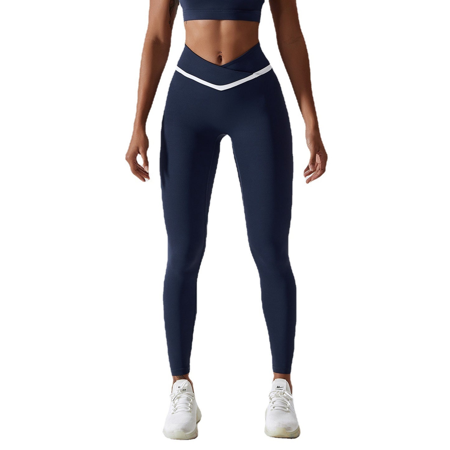 Woman wearing navy leggings with white accents on a white background